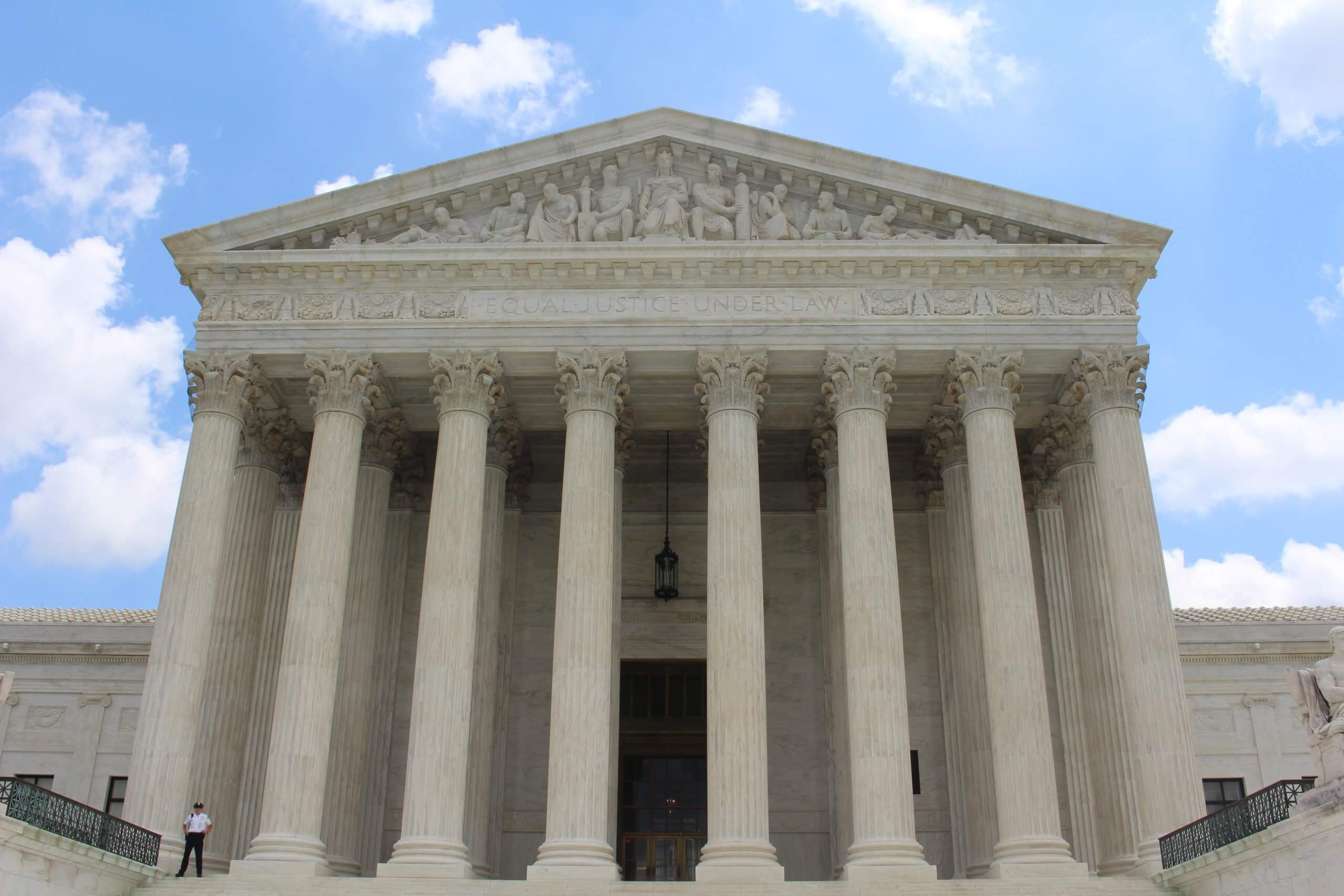 The U.S. Supreme Court building facade reading EQUAL JUSTICE UNDER LAW against a blue sky