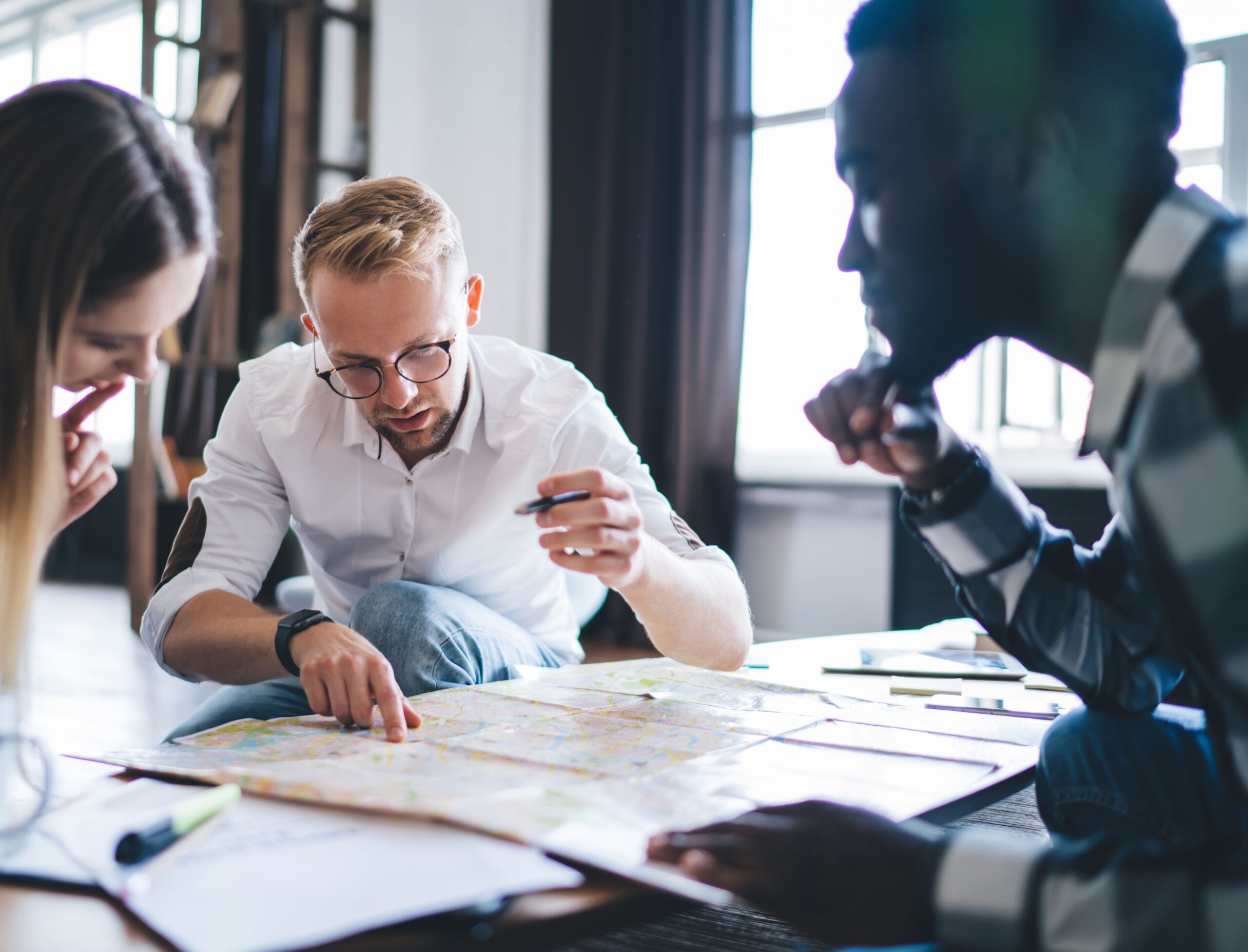 Consultants reviewing documents and mapping strategy together at a work table