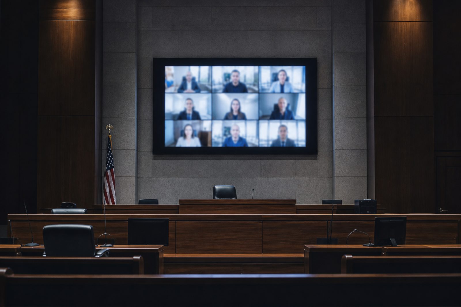 Courtroom with a large screen showing remote hearing participants in a video-conference grid